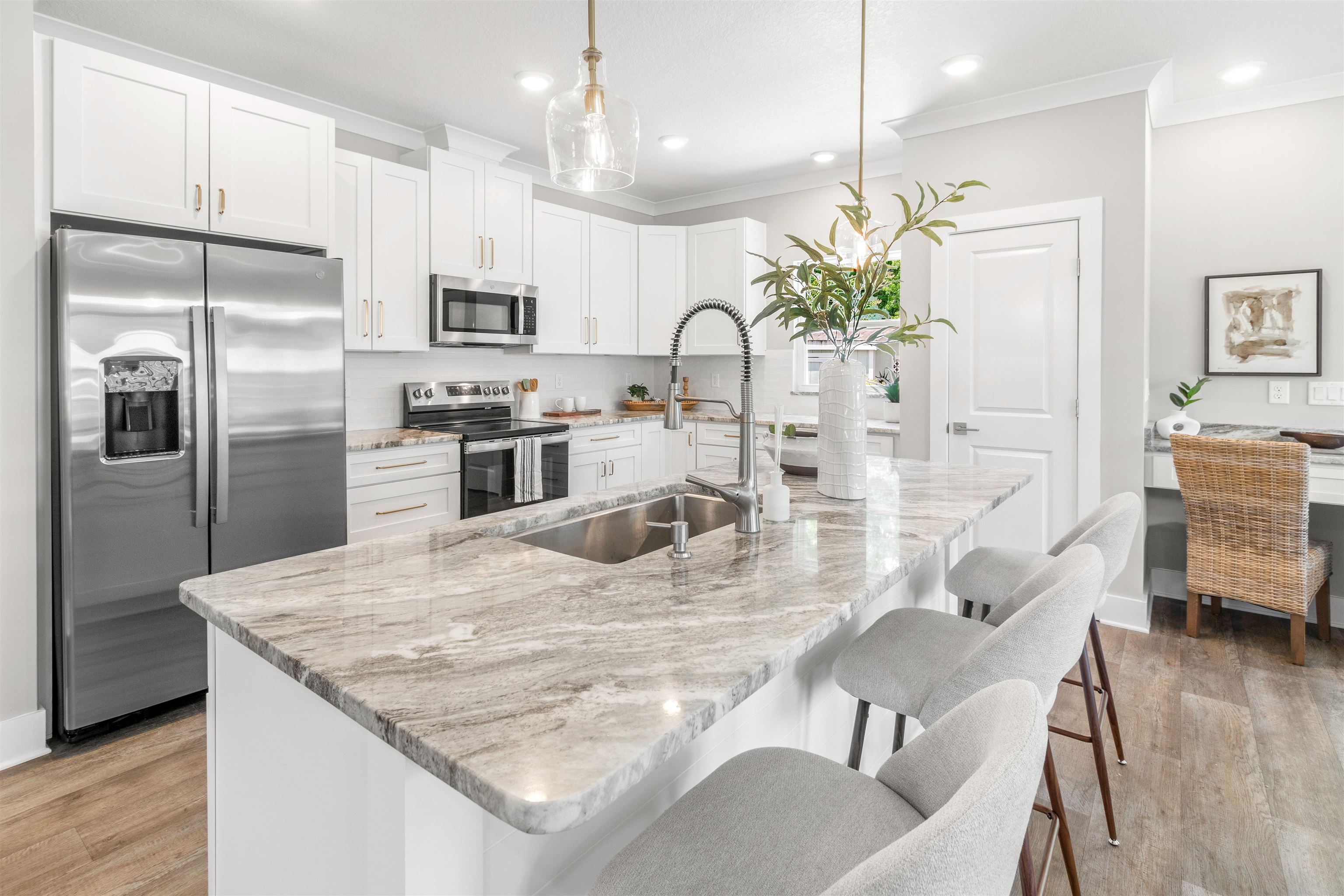 6779 Magnolia Lane St. Augustine, FL 32086 - Photo 15 of 61 a kitchen with stainless steel appliances granite countertop a refrigerator a stove a sink a dining table and chairs with wooden floor
