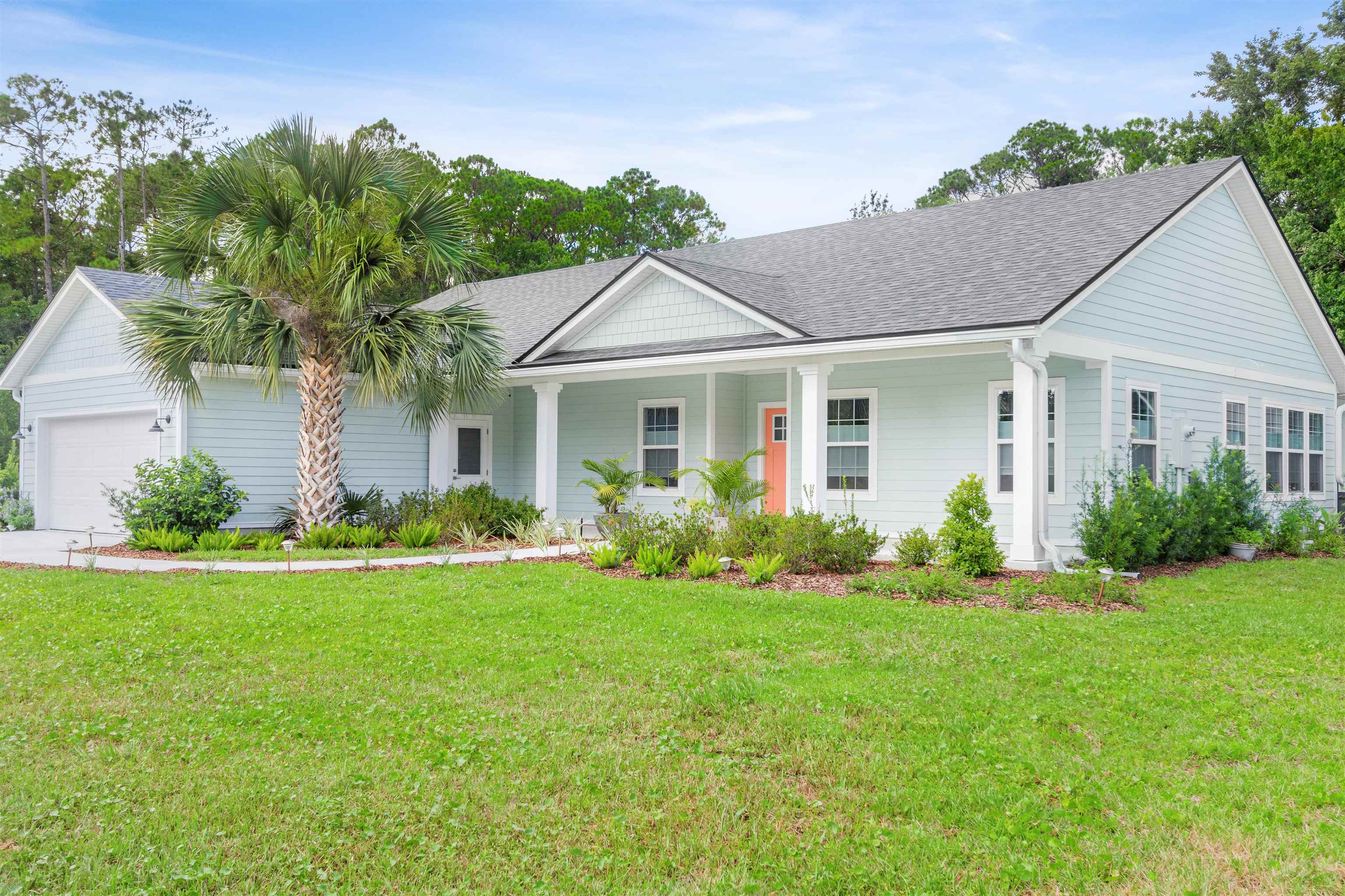 6779 Magnolia Lane St. Augustine, FL 32086 - Photo 44 of 61 a front view of a house with a yard and potted plants