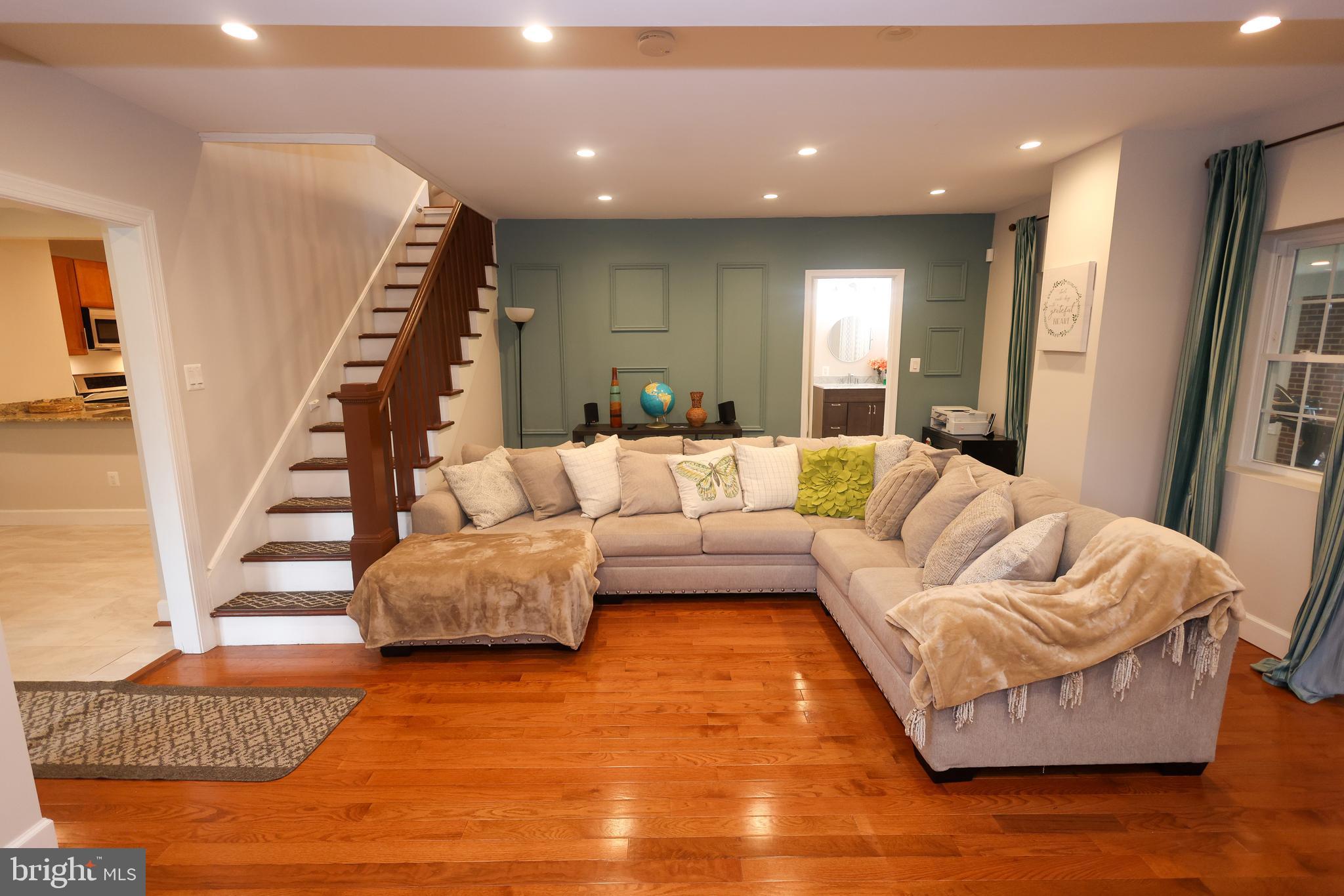 a living room with furniture and a wooden floor