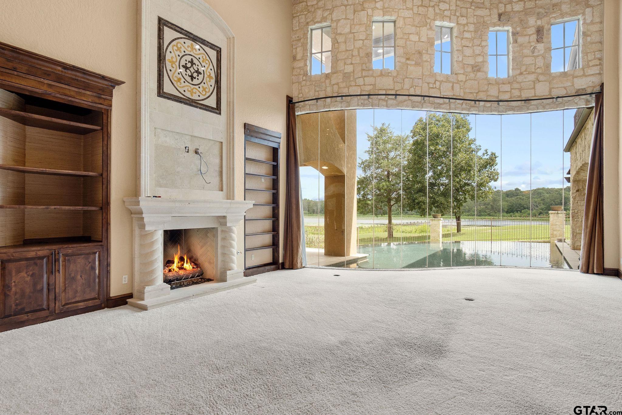 4331 Mark Hayes Court Tyler, TX 75709 - Photo 14 of 48 a view of an empty room with a fireplace and a floor to ceiling window