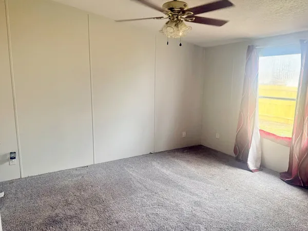 an empty room with a window and a livingroom