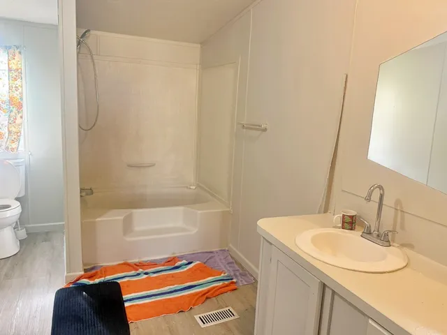 a bathroom with a sink a toilet and shower curtain