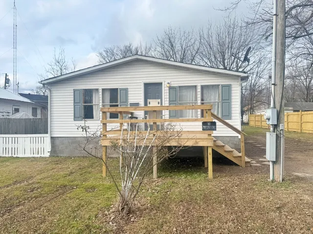 a view of a house with backyard and sitting area