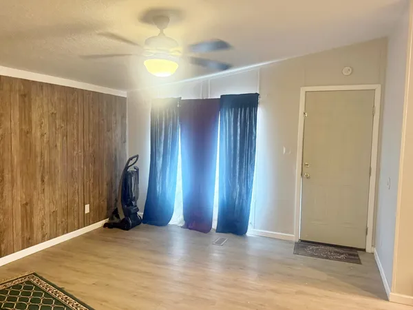 a view of an empty room with wooden floor