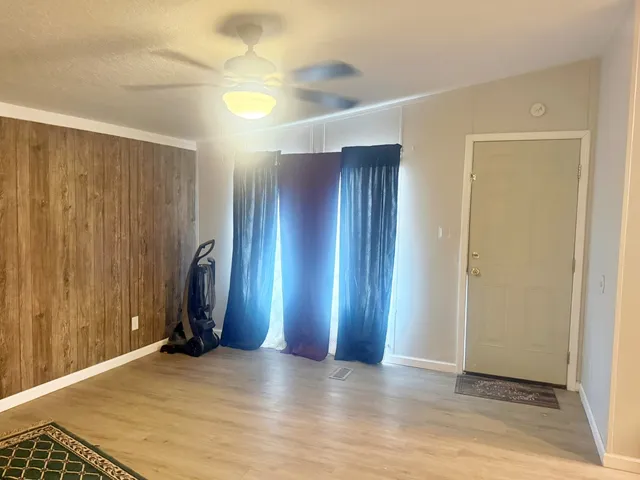a view of an empty room with wooden floor