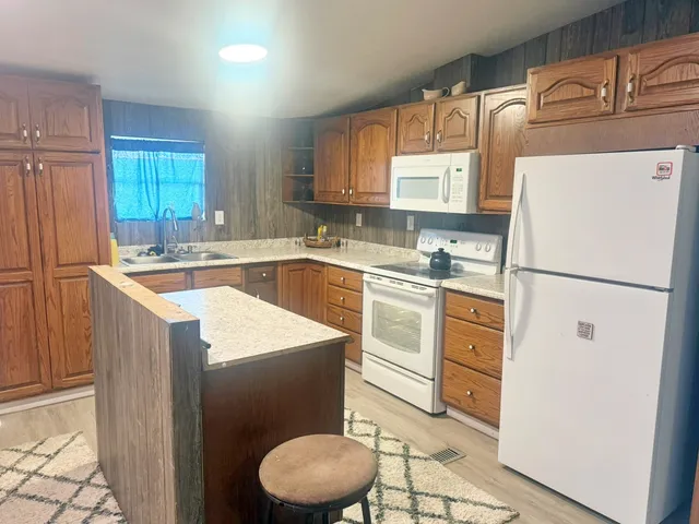 a kitchen with sink refrigerator and cabinets