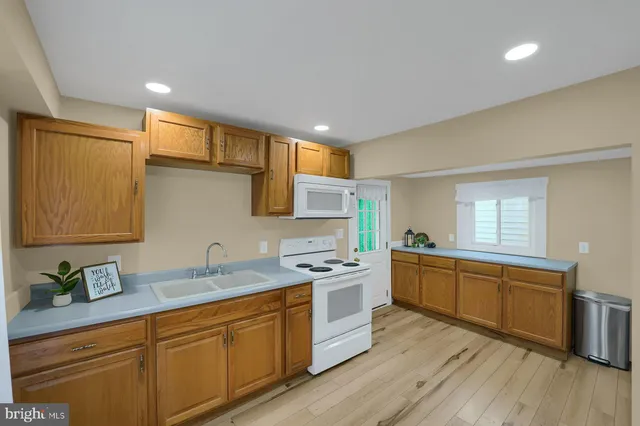 a kitchen with stainless steel appliances granite countertop a sink stove and wooden cabinets