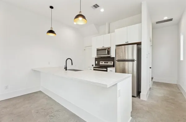 a kitchen with refrigerator and cabinets