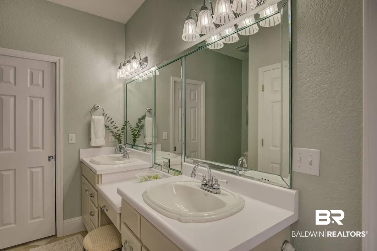 16297 Honey Road Summerdale, AL 36580 - Photo 19 of 24 Dual vanity with white countertops and chrome fixtures, illuminated by two sets of overhead vanity lighting