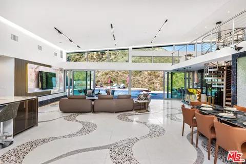 a living room with furniture a large window and stainless steel appliances