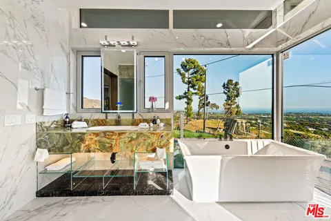 a bathroom with a tub sink and mirror