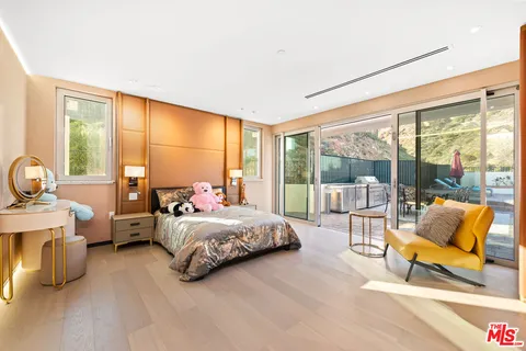 a bedroom with a bed and large windows