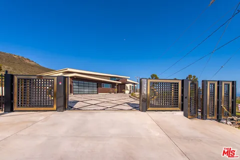 a view of a house with wooden fence