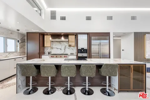 a kitchen with a sink a stove and chairs