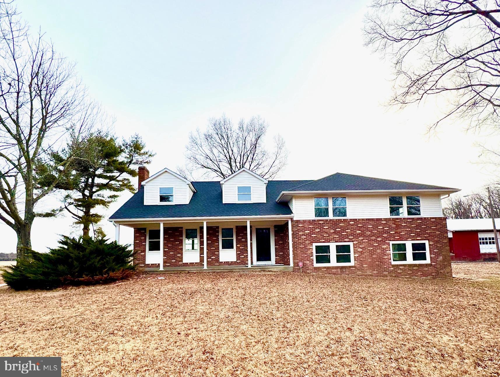 a front view of a house with yard and trees