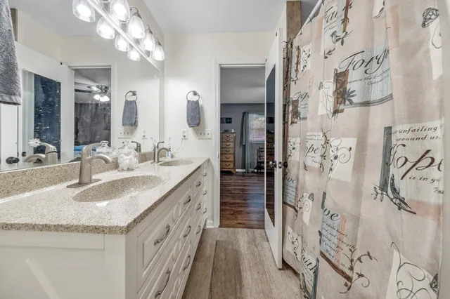 a bathroom with a granite countertop double vanity sink and a mirror