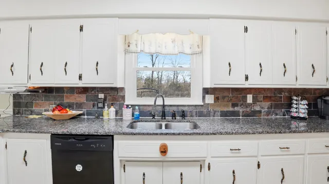 a bathroom with a sink vanity granite and a mirror