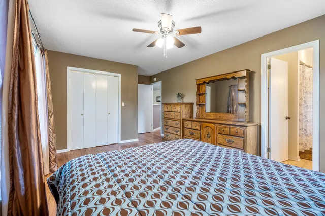 a bedroom with a bed and dresser with mirror