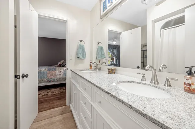 a en suite bathroom with a granite countertop sink and a mirror