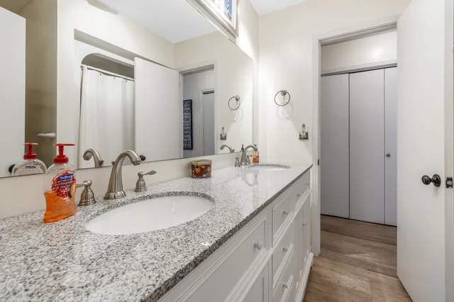 a bathroom with a granite countertop sink and a mirror