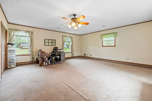 a view of a livingroom with furniture a ceiling fan and a window