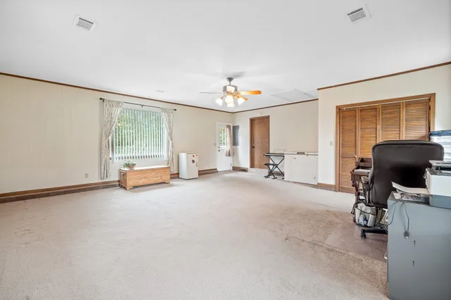 a view of a livingroom with workspace and a window