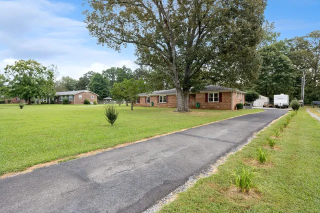 a view of a house with garden and trees