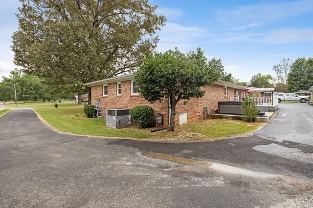 a view of a house with a big yard and large trees