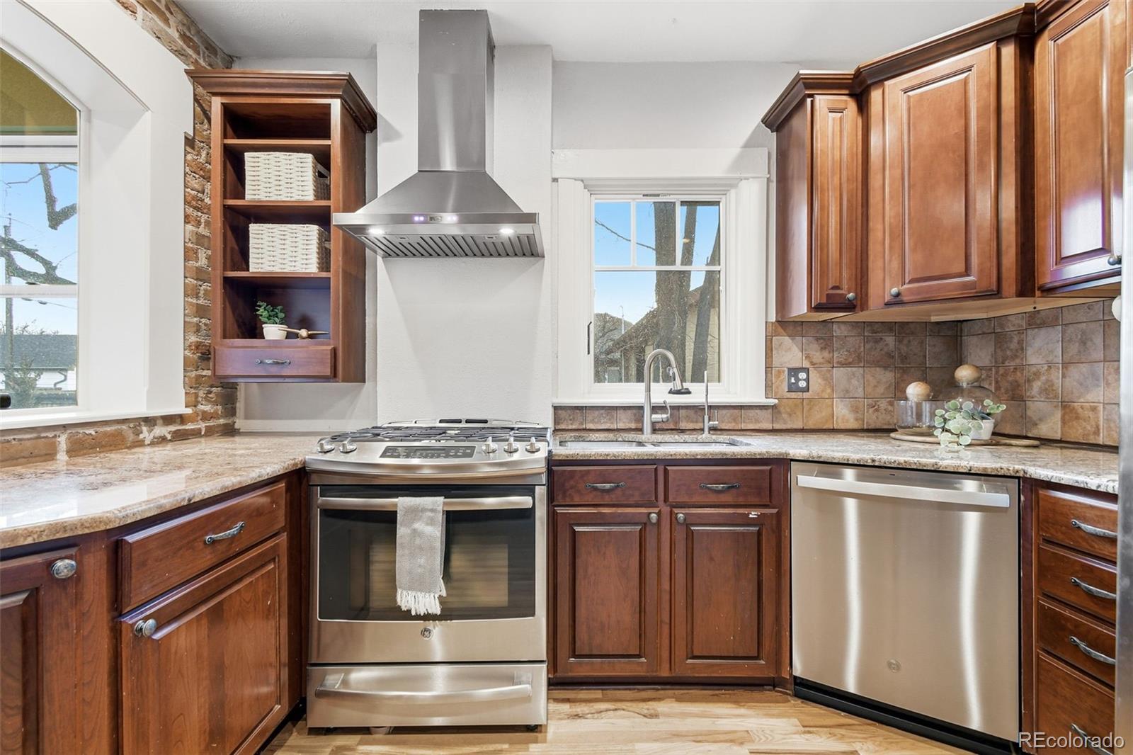 1318 South York Street Denver, CO 80210 - Photo 11 of 49 a kitchen with stainless steel appliances granite countertop a stove and a sink
