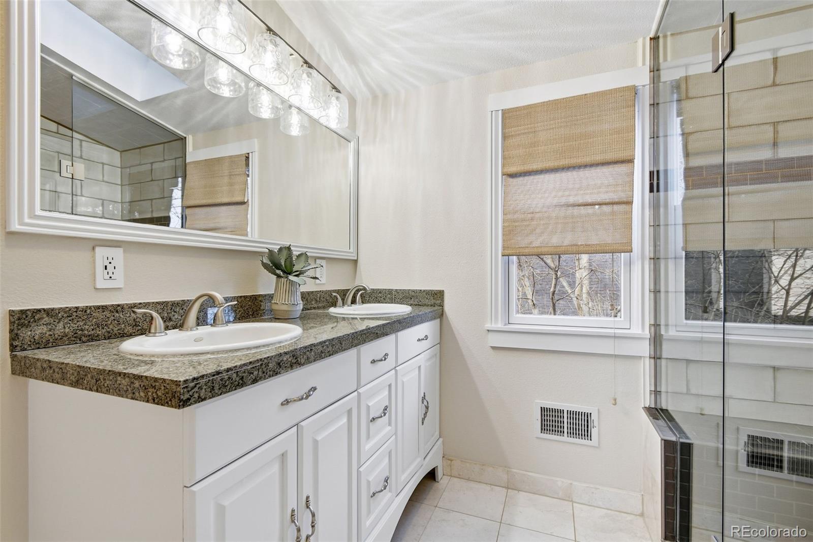 1318 South York Street Denver, CO 80210 - Photo 20 of 49 a bathroom with a granite countertop sink and a mirror
