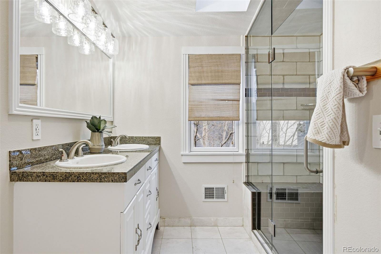 1318 South York Street Denver, CO 80210 - Photo 21 of 49 a bathroom with a granite countertop sink and a mirror