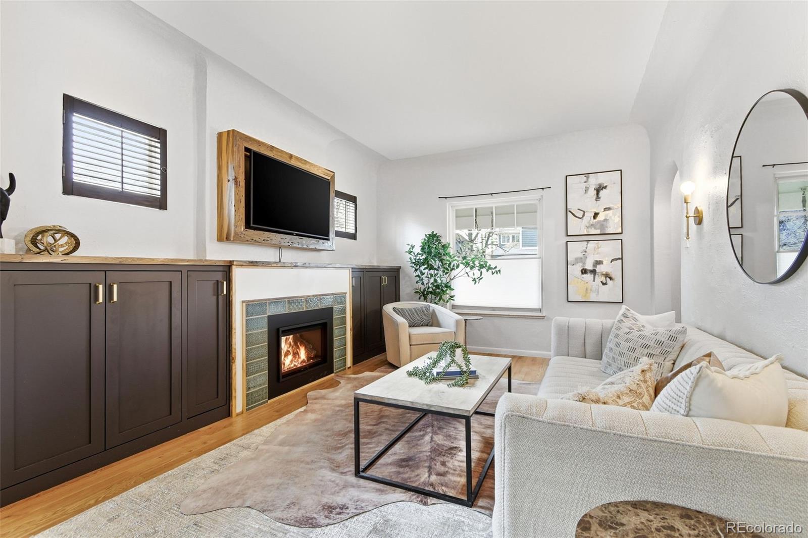 1318 South York Street Denver, CO 80210 - Photo 5 of 49 a living room with furniture a flat screen tv and a fireplace