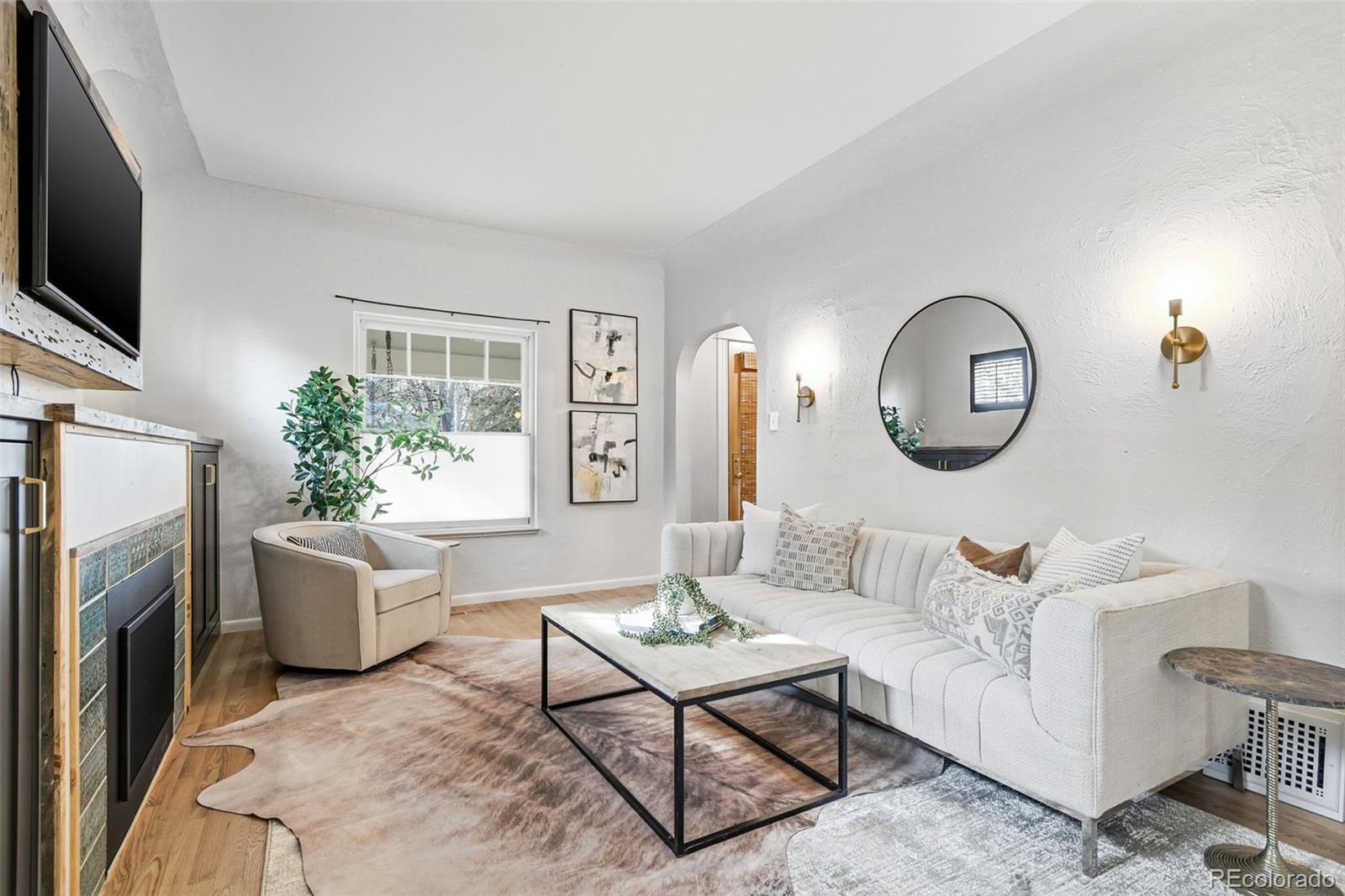 1318 South York Street Denver, CO 80210 - Photo 6 of 49 a living room with furniture a flat screen tv and a fireplace