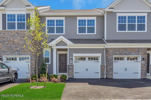 a front view of a house with a yard and a garage