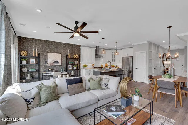 a living room with furniture kitchen view and a chandelier