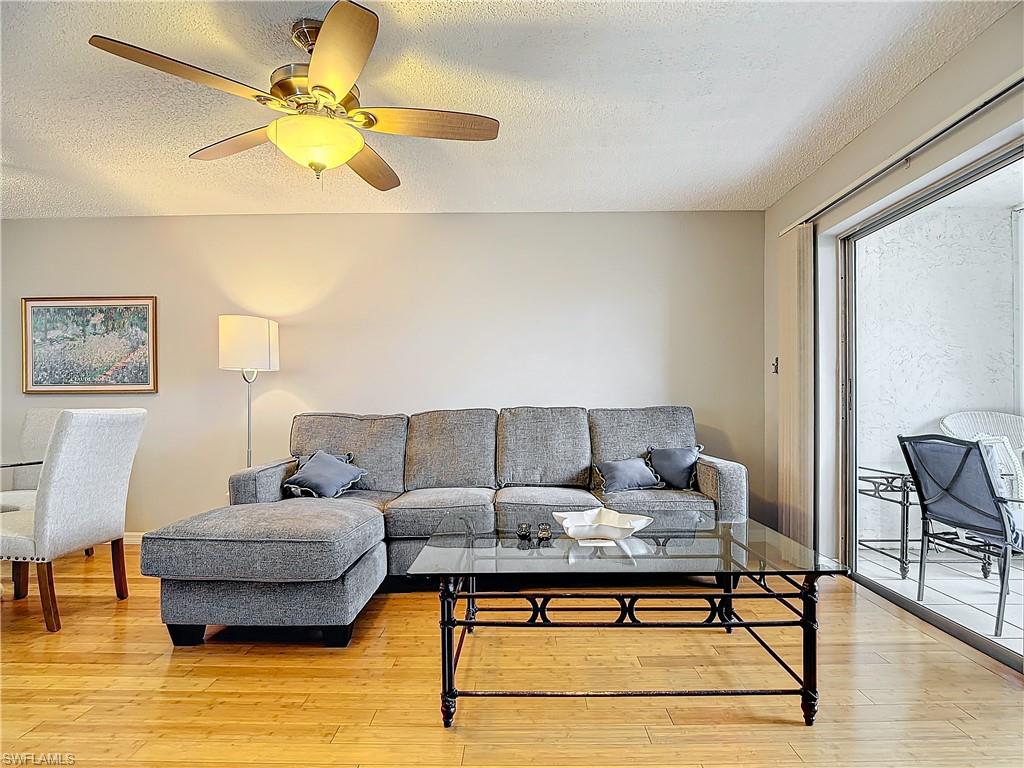 175 Turtle Lake Court, Unit 310 Naples, FL 34105 - Photo 14 of 34 Living room with ceiling fan, a textured ceiling, and light hardwood / wood-style floors