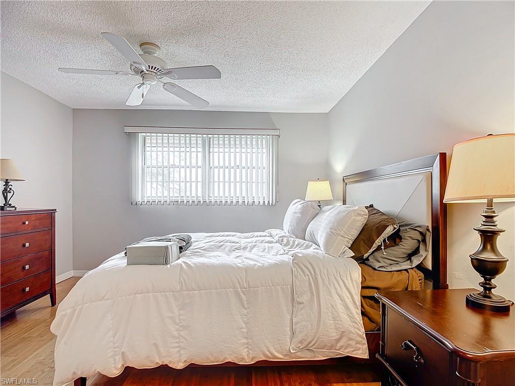 175 Turtle Lake Court, Unit 310 Naples, FL 34105 - Photo 20 of 34 Bedroom with ceiling fan, a textured ceiling, and light hardwood / wood-style floors