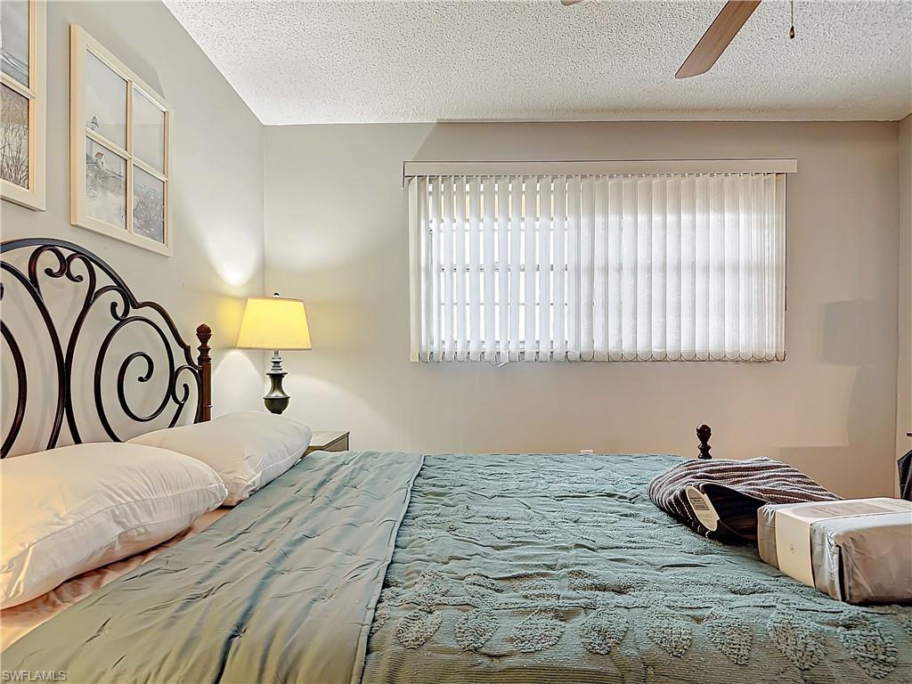 175 Turtle Lake Court, Unit 310 Naples, FL 34105 - Photo 23 of 34 Bedroom featuring ceiling fan and a textured ceiling