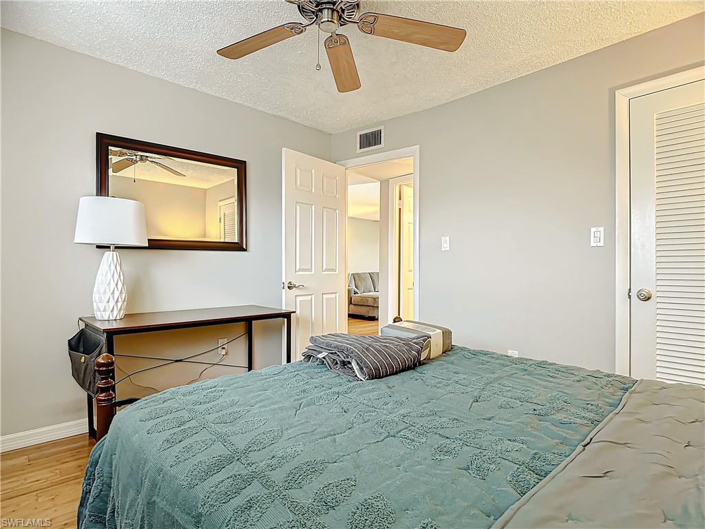 175 Turtle Lake Court, Unit 310 Naples, FL 34105 - Photo 25 of 34 Bedroom with hardwood / wood-style floors, a textured ceiling, and ceiling fan