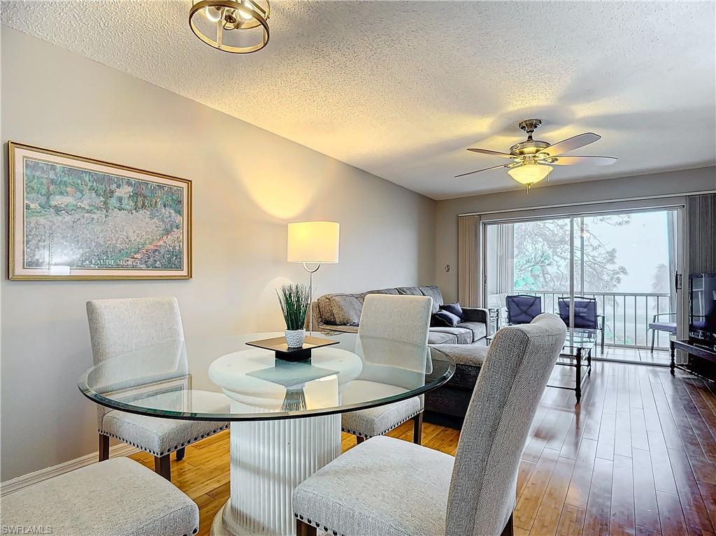 175 Turtle Lake Court, Unit 310 Naples, FL 34105 - Photo 10 of 34 Dining room featuring ceiling fan, hardwood / wood-style flooring, and a textured ceiling