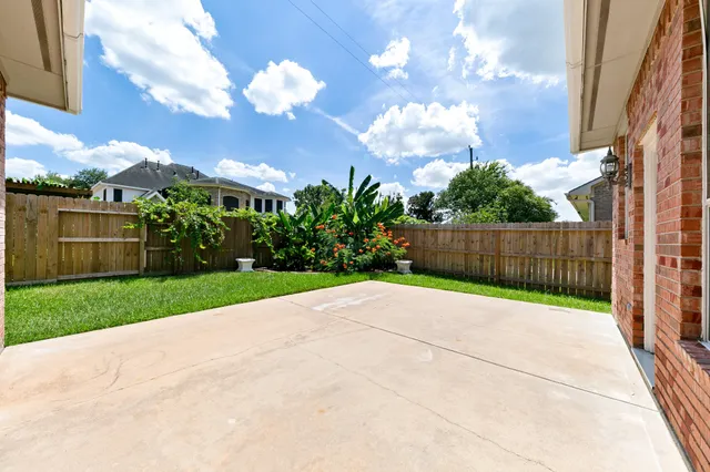 a view of backyard with garden and wooden fence