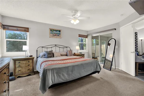 a bedroom with a bed a dresser and large window