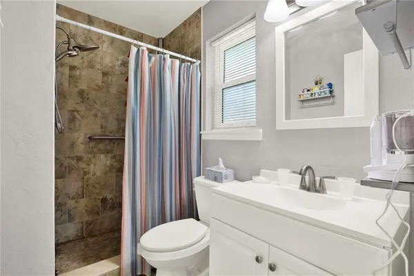 a bathroom with a sink a toilet and shower