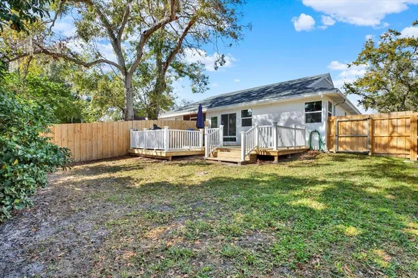 a view of a house with backyard and a tree