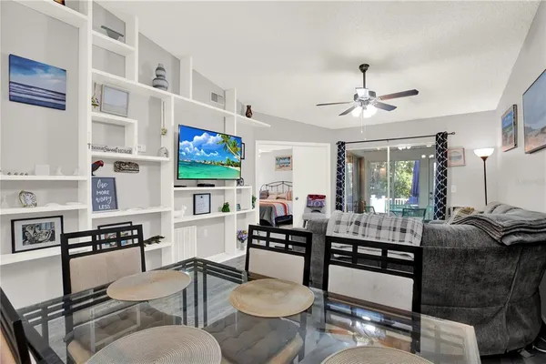 a living room with furniture kitchen view and a flat screen tv