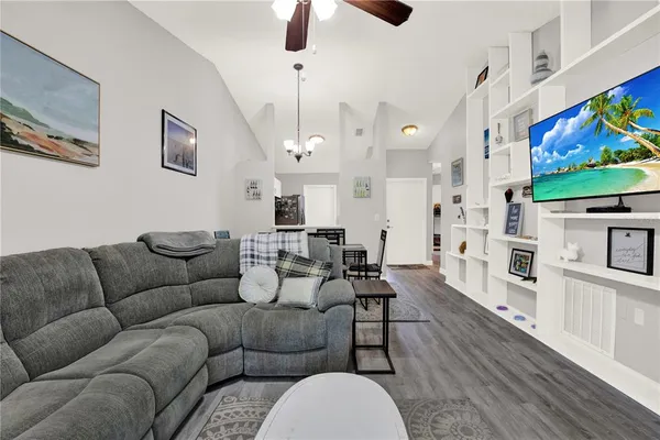 a living room with furniture kitchen view and a flat screen tv