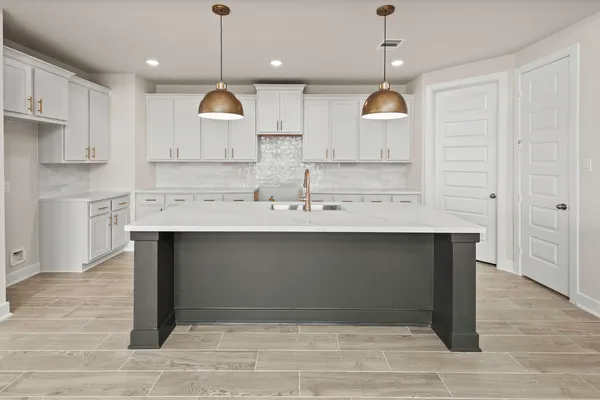 a kitchen with kitchen island granite countertop wooden cabinets and a chandelier