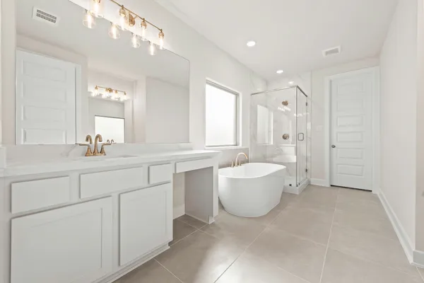 a spacious bathroom with a bathtub sink and mirror