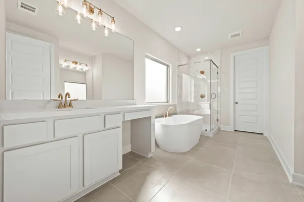 a spacious bathroom with a double vanity sink a large mirror and a bathtub