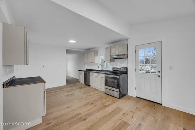 a kitchen with granite countertop a sink and a stove top oven